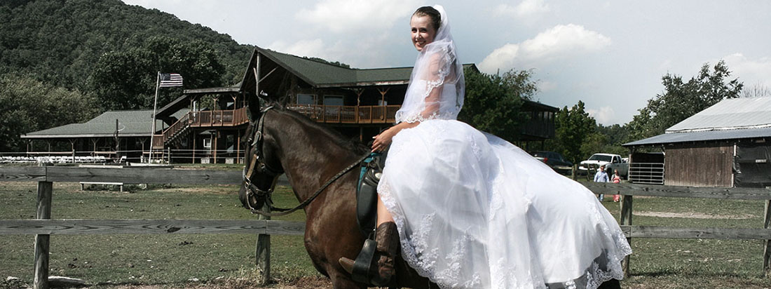Girl in wedding dress on horseback.